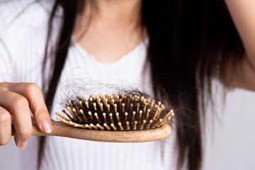 Healthy concept. Woman show her brush with damaged long loss hair and looking at her hair.