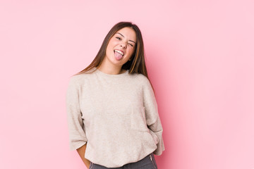 Young caucasian woman posing isolated funny and friendly sticking out tongue.