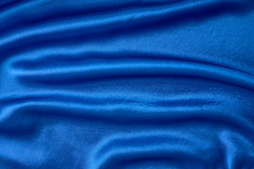 Fototapeta na wymiar Blue silk background with a folds. Abstract texture of rippled satin surface
