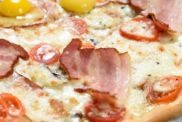 Tasty pizza with cheese, quail eggs, spices and tomatoes