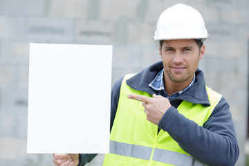 smiling worker holding a white placard