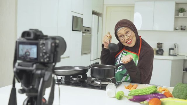 Elderly Muslim female influencer cooks healthy foods