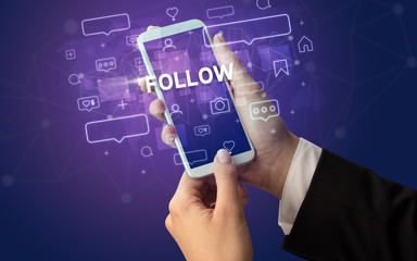 Female hand typing on smartphone with FOLLOW inscription, social media concept