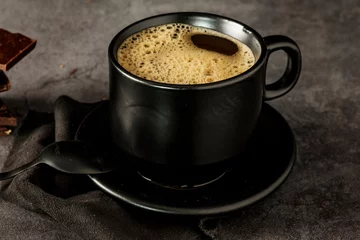 Fotobehang Black coffee cup with coffee on a dark background. With copy space for your text. Cup of coffee on a black background low key copy space. © yuriivd