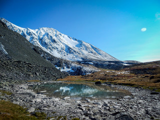 Naklejka na ściany i meble Meltwater lake on top of snow-capped mountains