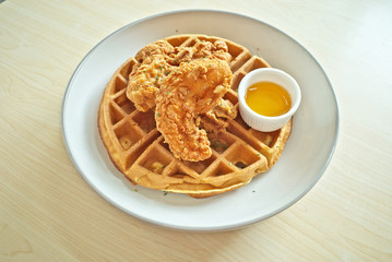 Hot deep-fried crunchy super crispy southern-style chicken with  fluffy classic Belgian waffles recipe served with sweet honey sauce is delicious fusion cuisine as famous food menu in restaurant