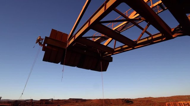 High definition footage of industry rope access technician inspector abseiling working at height placing safety rope protection on sharp edges during concrete spalling inspection on counterweight 