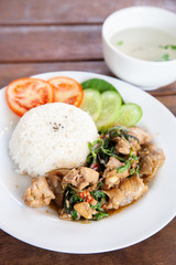Rice topped with stir fried chicken and basil