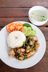 Rice topped with stir fried chicken and basil