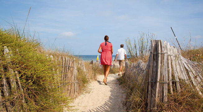 Un homme et une femme se rendent à la plage en été.