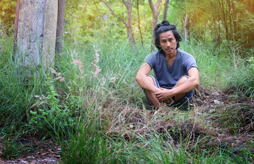 Naklejka na ściany i meble Asian Thai middle aged man long hair in green field on mountain with trees grass element at Thailand. Adult men activity lifestyle with nature forest adventure outdoor. countryside travel concept.