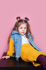 Cute little girl model in denim sitting in studio Fashion concept