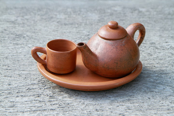 brown clay pot or tea pot and cup
