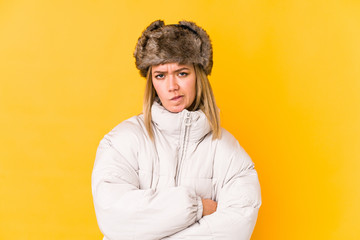 Young blonde woman wearing a winter clothes isolated Young blonde woman isolated on yellow background frowning face in displeasure, keeps arms folded.< mixto >