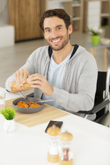 happy disabled man in wheelchair having a meal