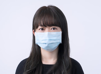 Young Asian woman portrait, wearing a medical surgical blue face mask to prevent infection sick, air pollution isolated on white background, copy space, close up, cut out
