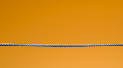 a empty rope stretched on a orange background