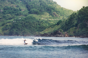 surfer at Wediombo beach, Yogyakarta, Indonesia