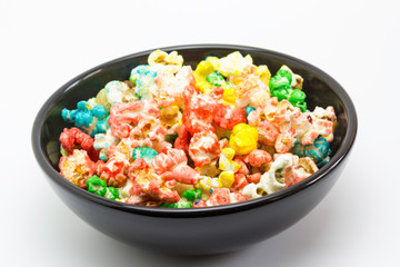 Bol de palomitas de maíz bañadas de azúcar de colores con fondo blanco