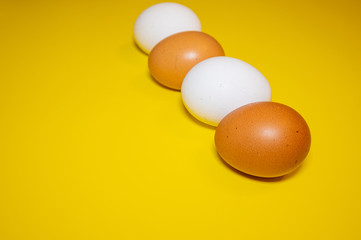 White and brown Easter eggs bright yellow background. Concept happy Easter. Minimalism concept. Top view.
