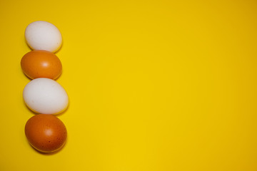 White and brown Easter eggs bright yellow background. Concept happy Easter. Minimalism concept. Top view.