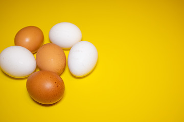 White and brown Easter eggs bright yellow background. Concept happy Easter. Minimalism concept. Top view.