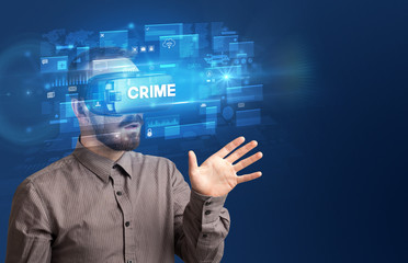 Businessman looking through Virtual Reality glasses with CRIME inscription, innovative security concept