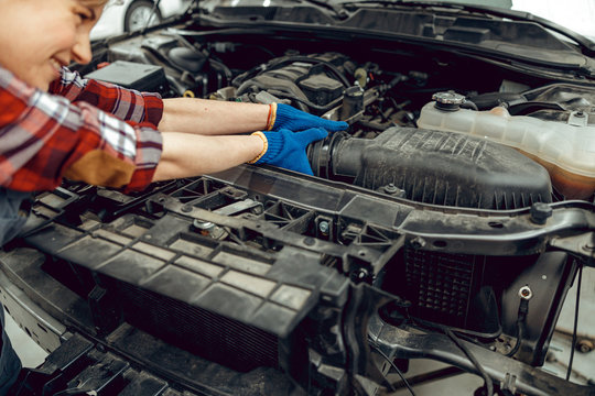 Female Technician Replacing A Car Coolant Hose