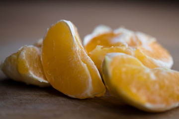 Pieces of fresh orange lying on a wooden board