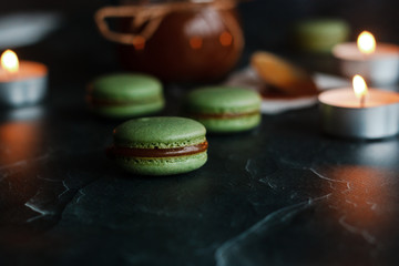 Macaroons. Delicious french dessert. Romantic composition with a jar of caramel and candles