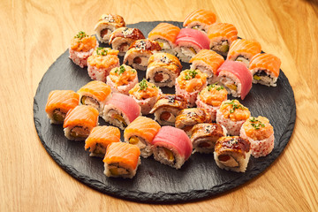 Various kinds of sushi roll set served on black stone. Japanese food