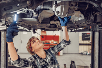 Obraz na płótnie Canvas Experienced mechanic staring at the car underside