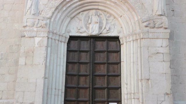 main door of medieval church, tilt shot of Saint Andrew's cathedral in Venzone (Italy)