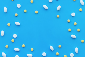 Multicolored pills on a blue background with a space for text. The view from the top. The concept of health.