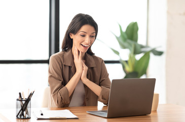 Young businesswoman using laptop sitting at cafe