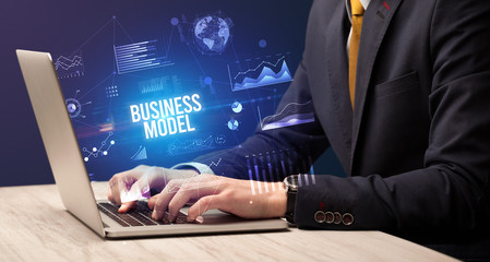 Fototapeta na wymiar Businessman working on laptop with BUSINESS MODEL inscription, new business concept