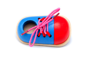 A shoe of plywood - development toy for kids to learn how to lace shoelaces isolated on white background