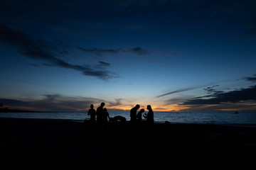 Sunset silhouette on the beach of people and sky
