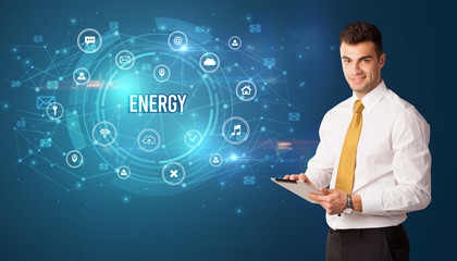 Businessman thinking in front of technology related icons and ENERGY inscription, modern technology concept