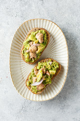 Avocado and tuna toasts on a plate.