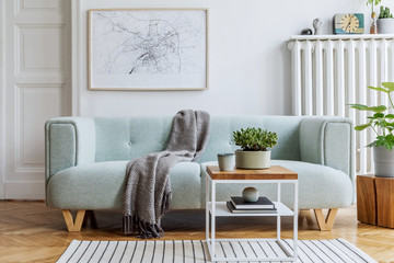Stylish scandinavian living room interior with design mint sofa, furnitures, mock up poster map, plants, and elegant personal accessories. Modern home decor. Bright and sunny space. Template. 