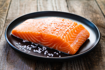 Fresh raw salmon steaks on wooden board