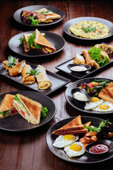 Traditional breakfast with fried eggs, sausages, beans, mushrooms, grilled tomatoes and bacon on wooden background. Top view