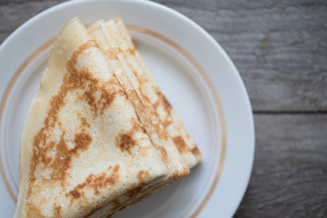 Pile of thin pancakes on a plate . Top view (selective focus)
