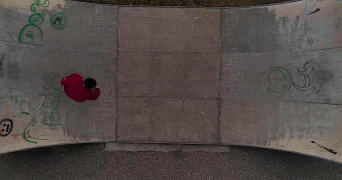 young skateboarder training on a cold winter day on a mini ramp