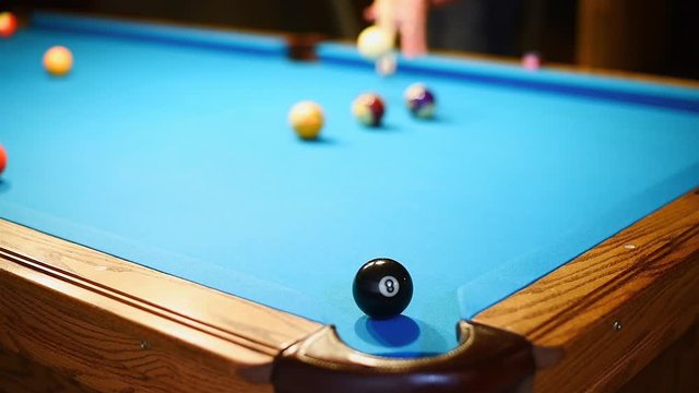 Billiards jump shot over other balls to pocket the 8-ball in the corner pocket
