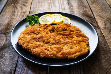 Schnitzel with  lemon on timber background