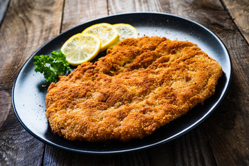 Schnitzel with  lemon on timber background
