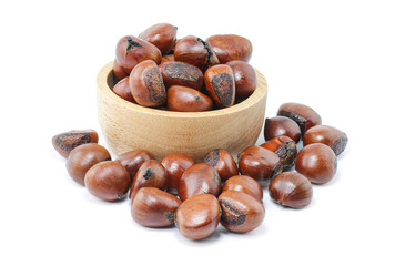 Close up of roasted horse chestnuts in wooden bowl isolated on white background with clipping path.