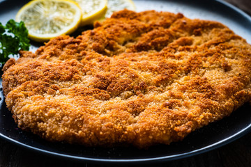 Schnitzel with  lemon on timber background